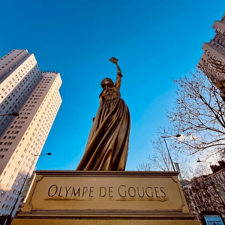 Les 10 statues femmes en or de la Porte de la Chapelle 13 Statue femme en or en contre-plongée, immeubles du quartier Porte de la Chapelle Paris 18 en arrière-plan